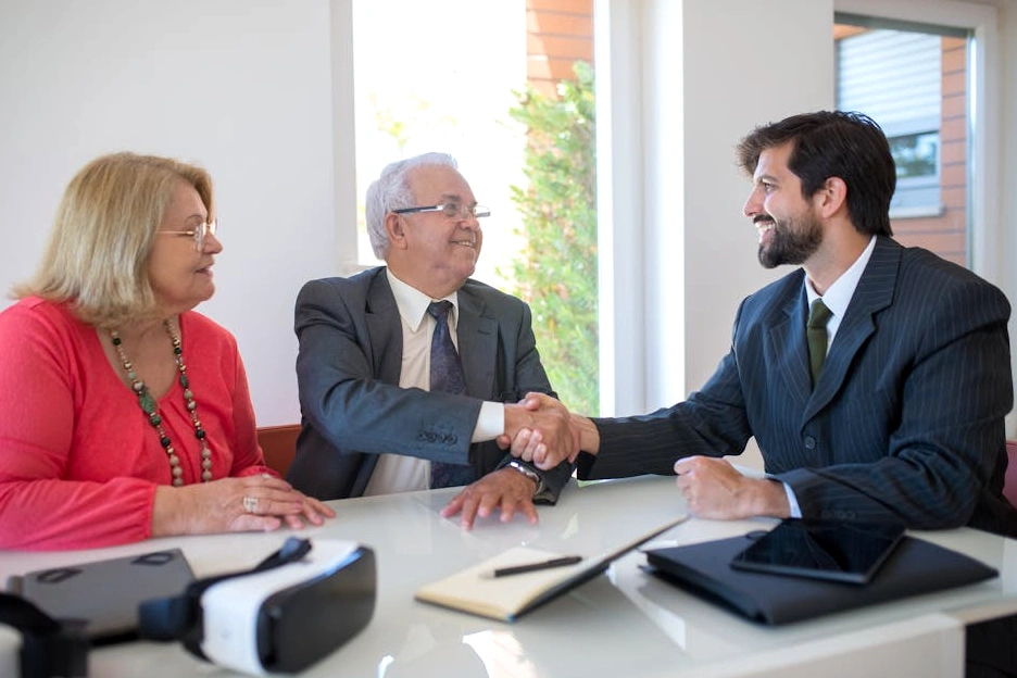 Consulente sorridente stringe la mano a un cliente soddisfatto.